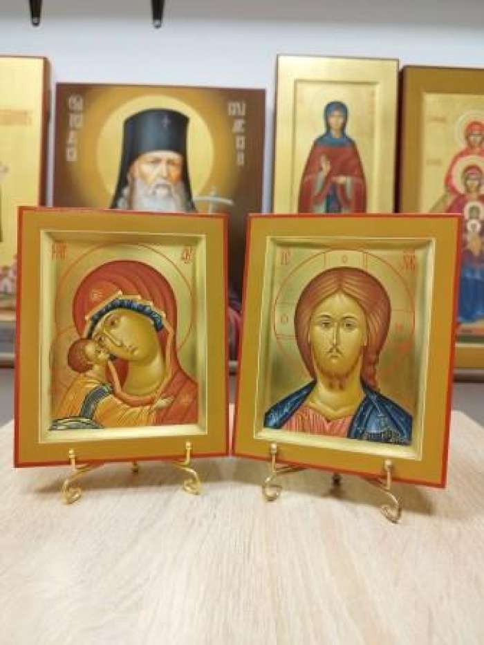 Богородица «Игоревская» и Спаситель в венчальной паре с позолотой, две отдельные иконы в коричневых рамах на подставках